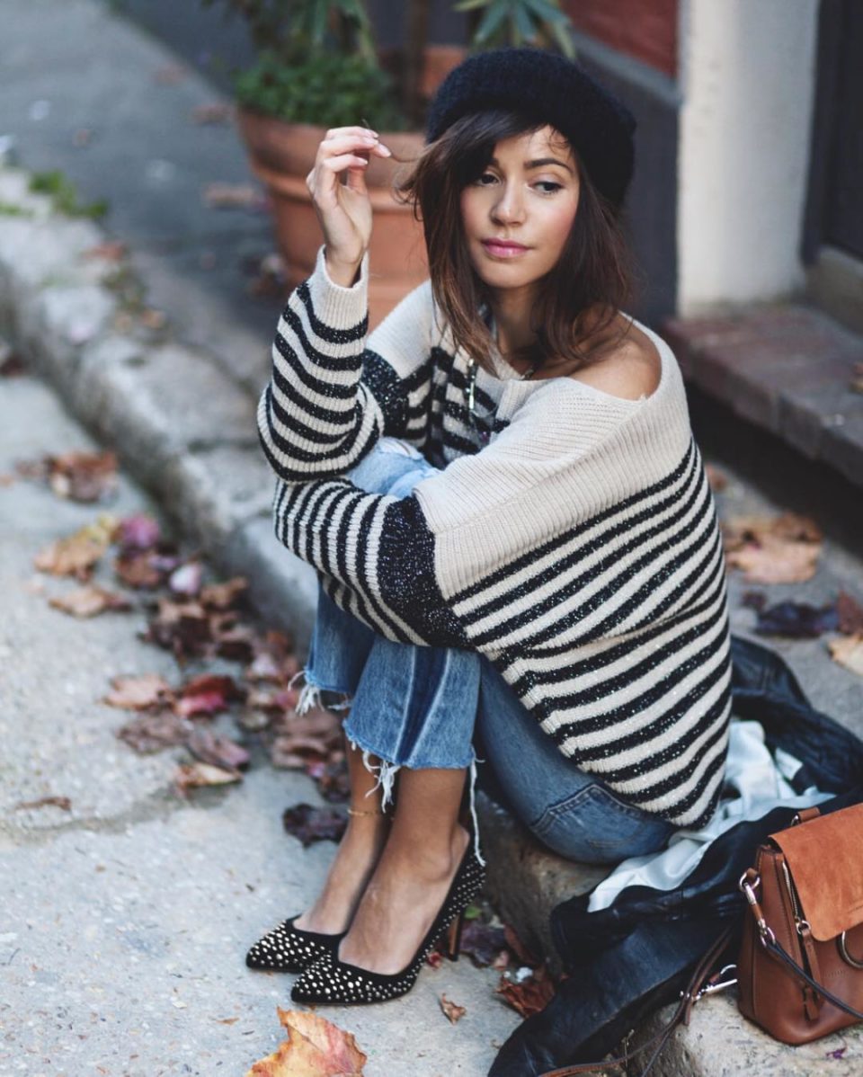 Woman wearing a black beret with a striped sweater and jeans