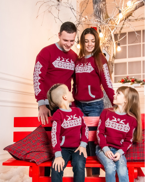 Couple in matching burgundy Christmas sweatshirts