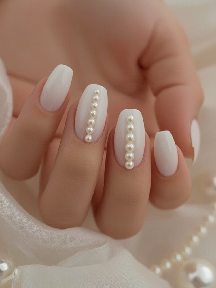 Elegant white nails adorned with pearl embellishments