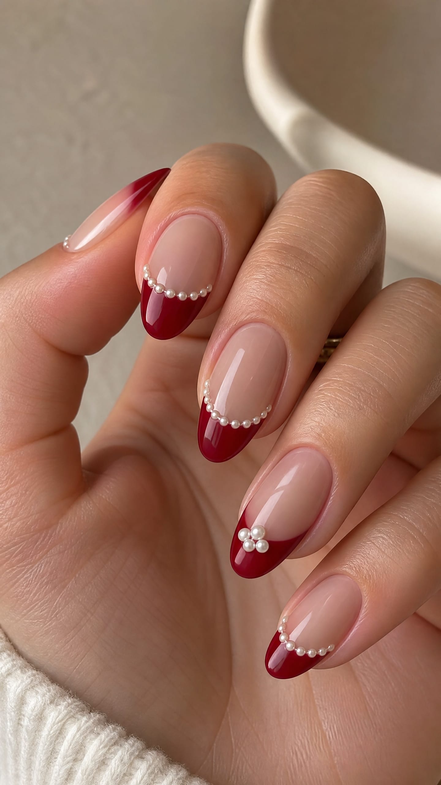 Red French tip nails with delicate pearl embellishments