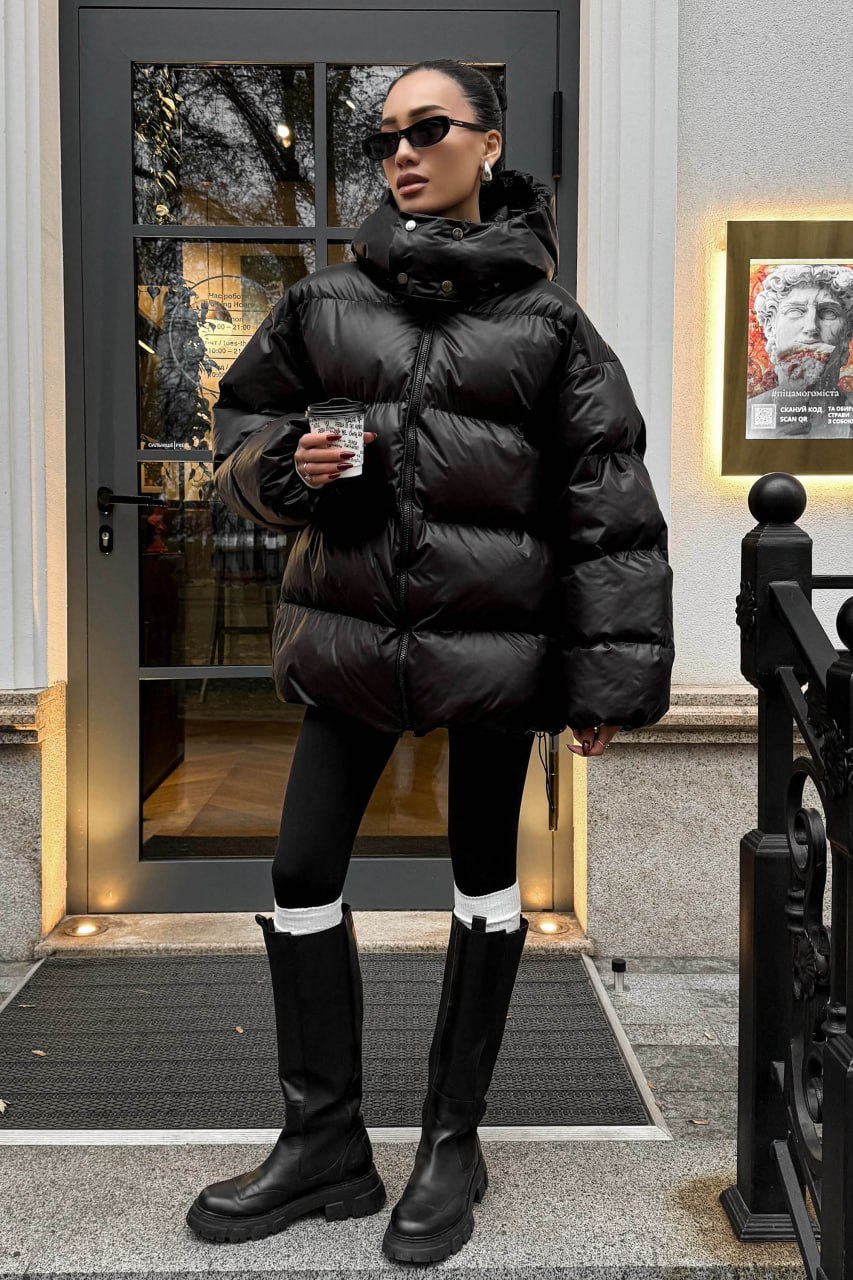 Woman in an oversized black puffer jacket with black leggings