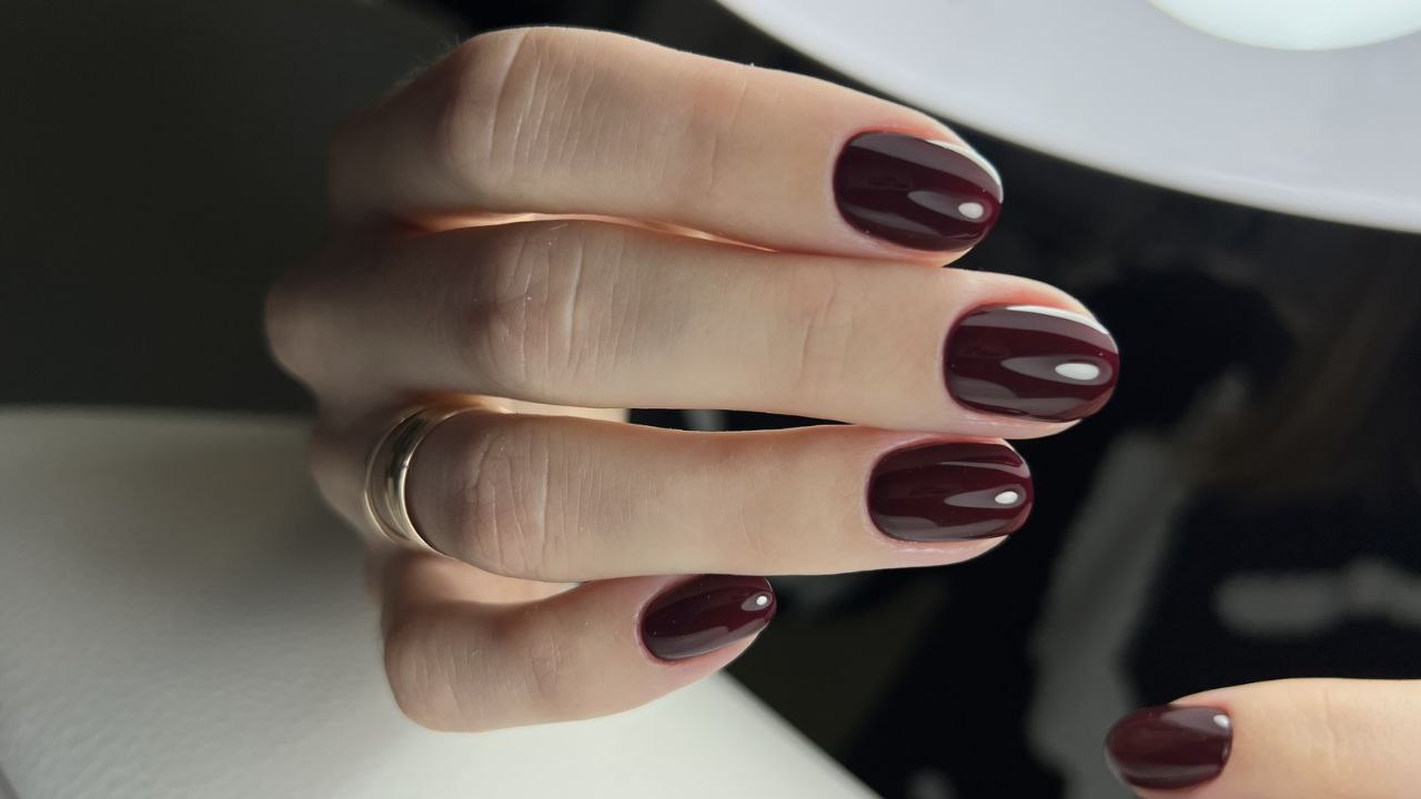 Short oval nails in deep oxblood red with glossy finish