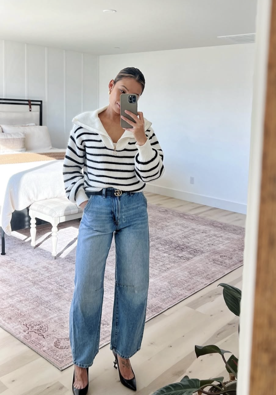 Striped quarter-zip sweater with light-wash barrel-leg jeans, black belt and pointed black heels