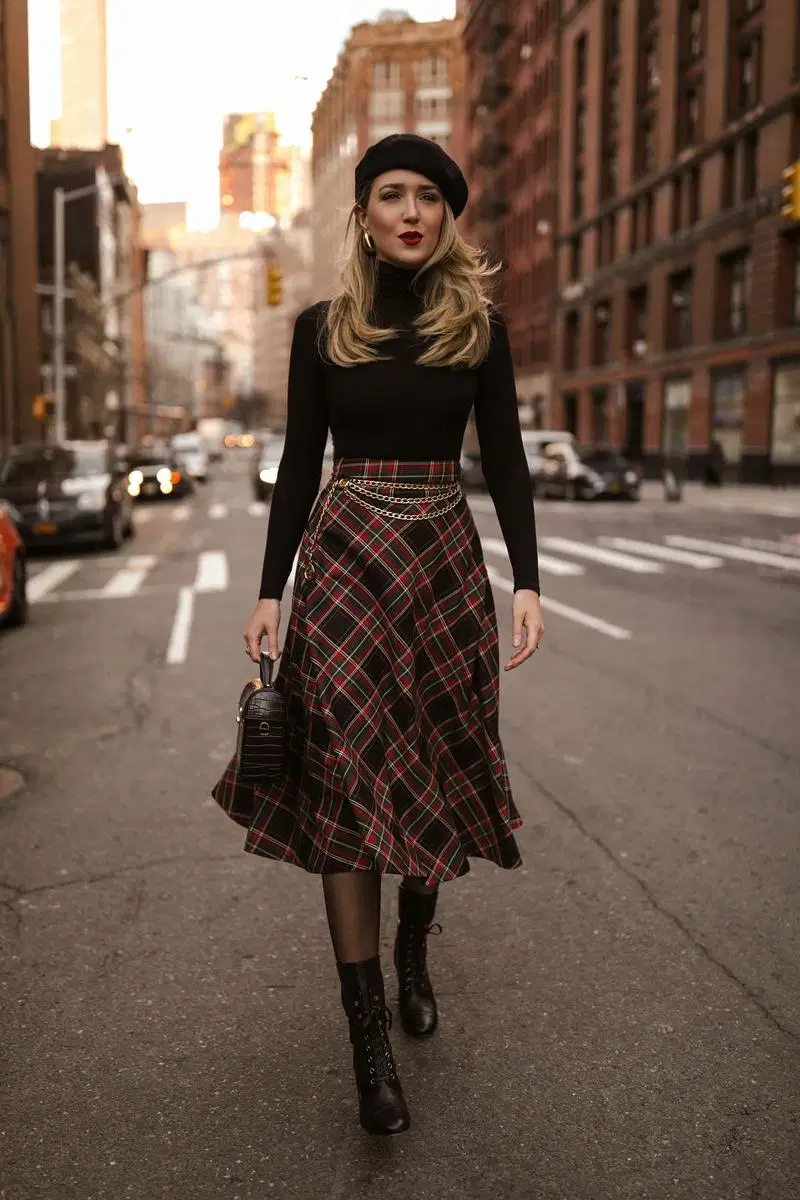 Woman wearing a beret with a plaid midi skirt, black turtleneck and knee-high boots