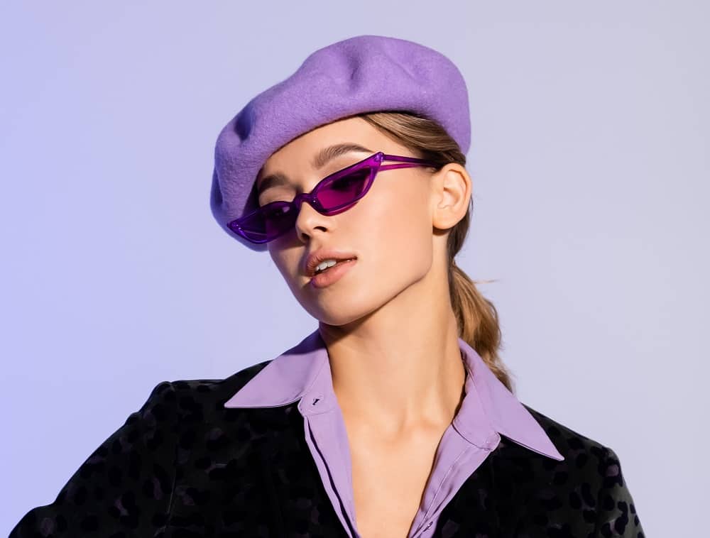 Woman in a purple beret with a sleek blonde low ponytail