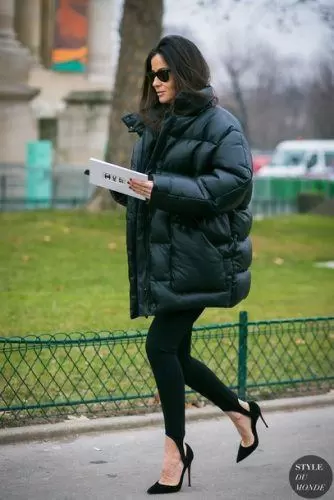 Woman wearing an oversized forest green puffer with fitted black bottoms