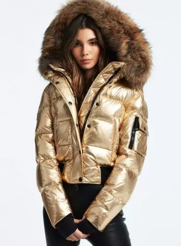Woman wearing a metallic gold cropped puffer jacket with black skinny jeans