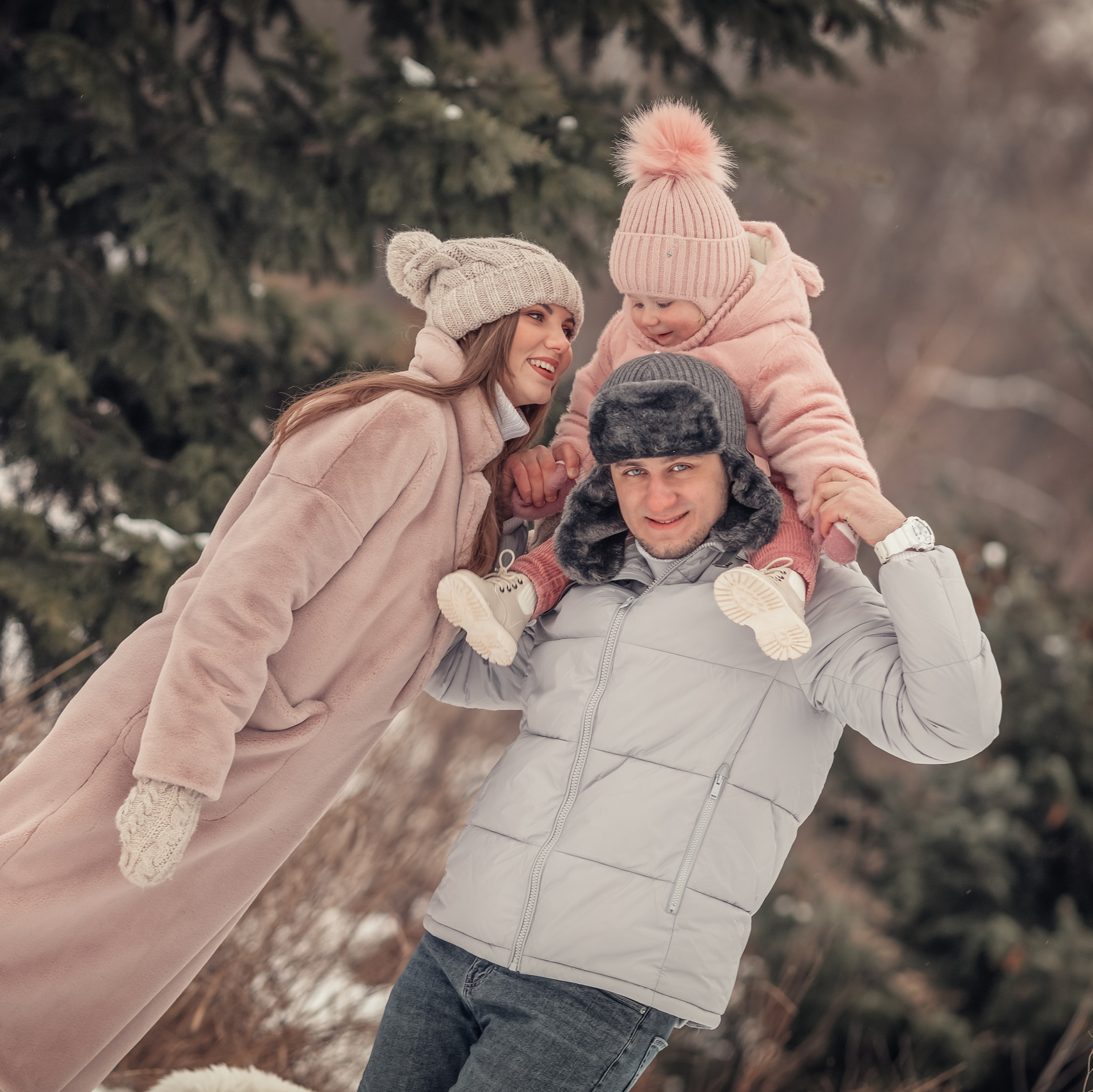 Family in forest green winter coats posing for a photo