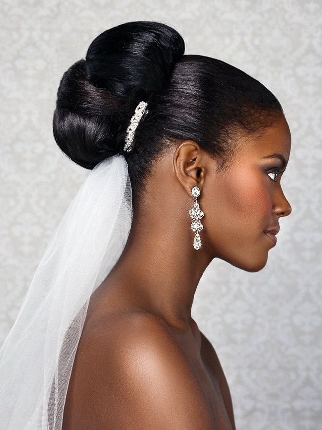 Bride wearing a high polished bun with a veil and jeweled comb
