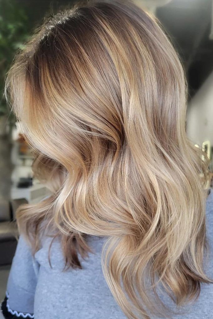 Honey blonde hair with dark smudged roots and soft balayage