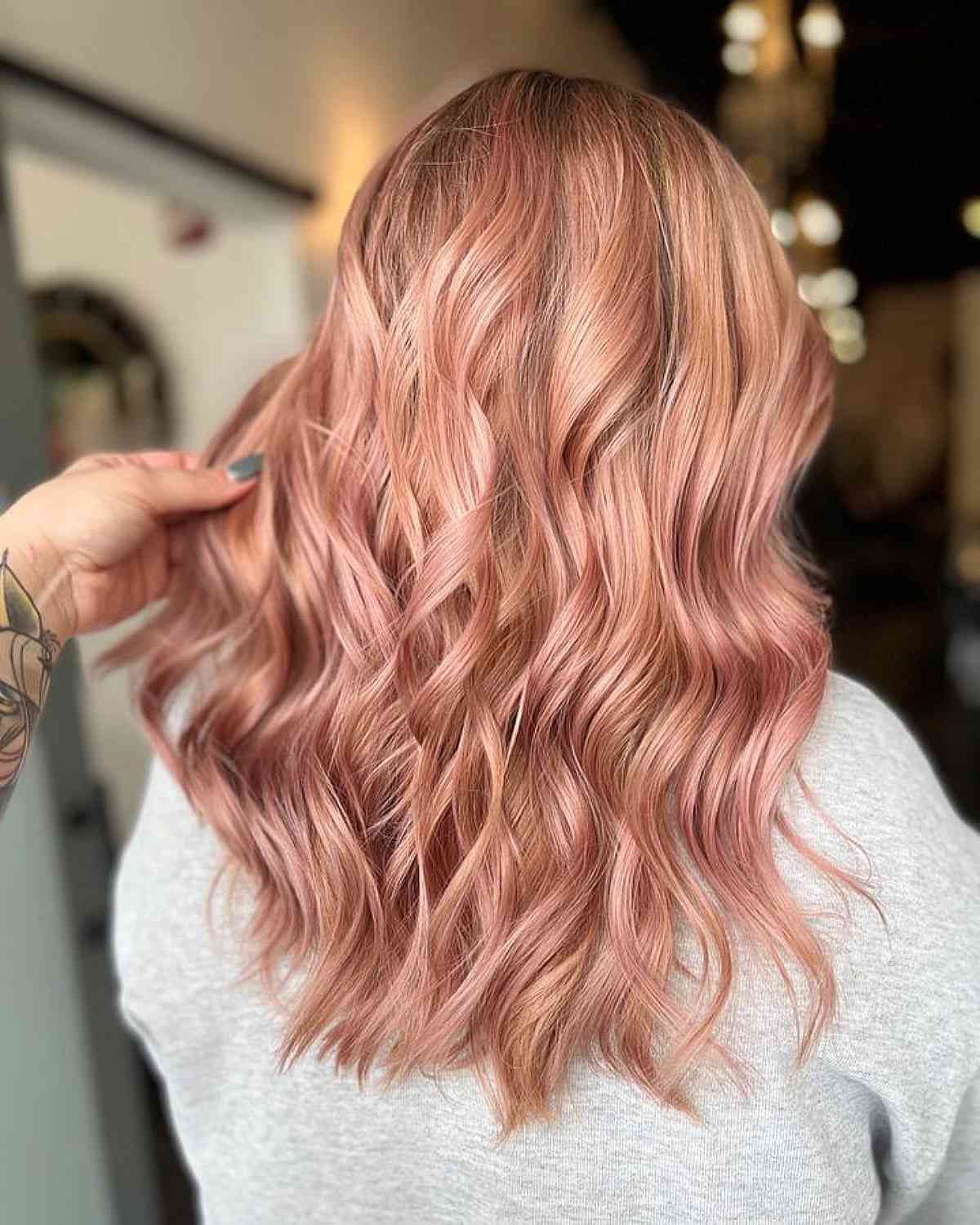 Rose gold tinted hair in soft medium waves
