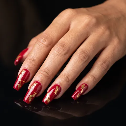 Red coffin nails with metallic gold foil flake accents