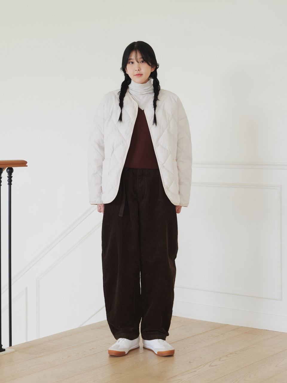 Woman in a quilted jacket with a striped top and corduroy pants, casual winter outfit