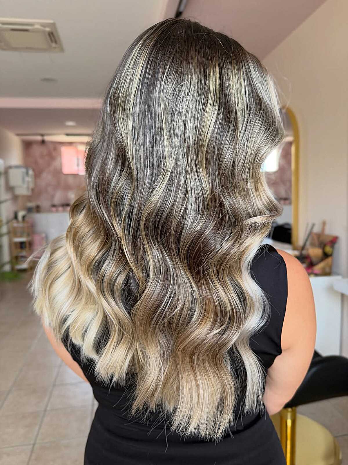 Wavy champagne blonde hair with soft dark shadow roots