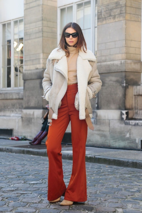 Woman wearing a shearling aviator jacket with high-waist trousers