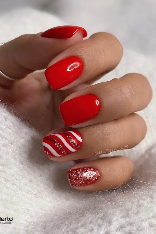 Short oval nails painted in glossy classic cherry red