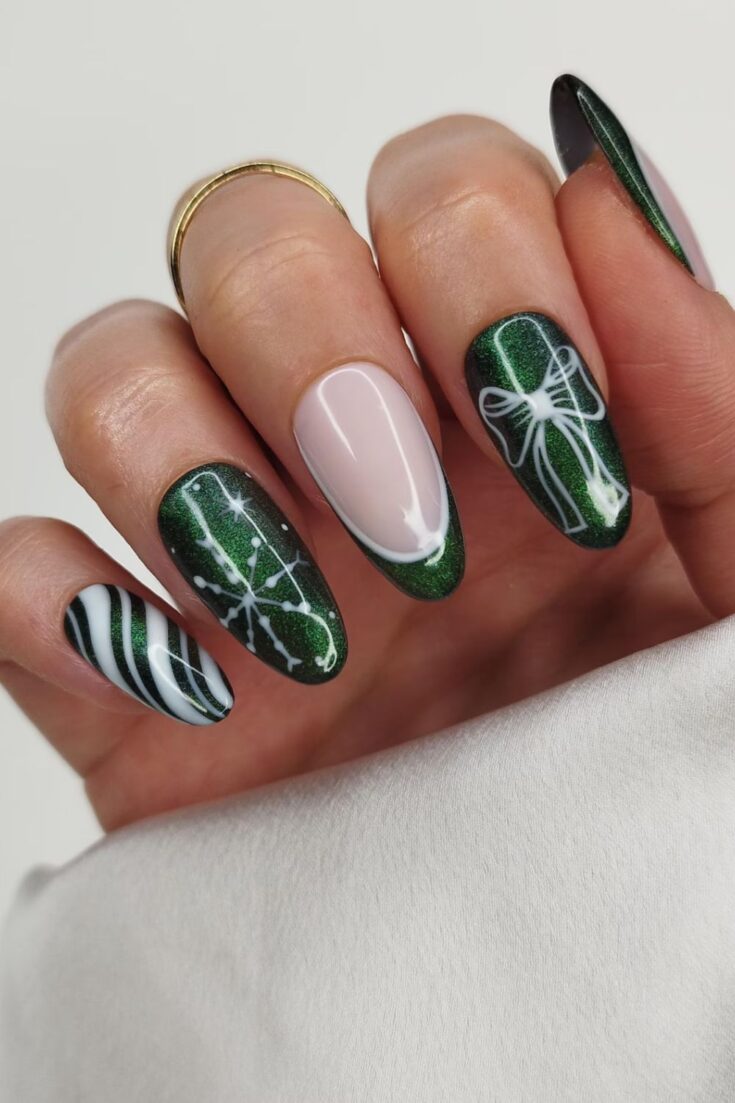 Almond nails in dark green cat-eye glitter with white bow outline, candy-cane stripes and snowflake art