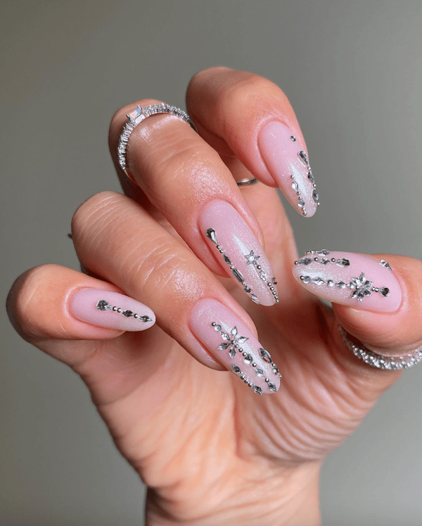 Soft pink gel nails with 3D rhinestone crystal accents for New Year's