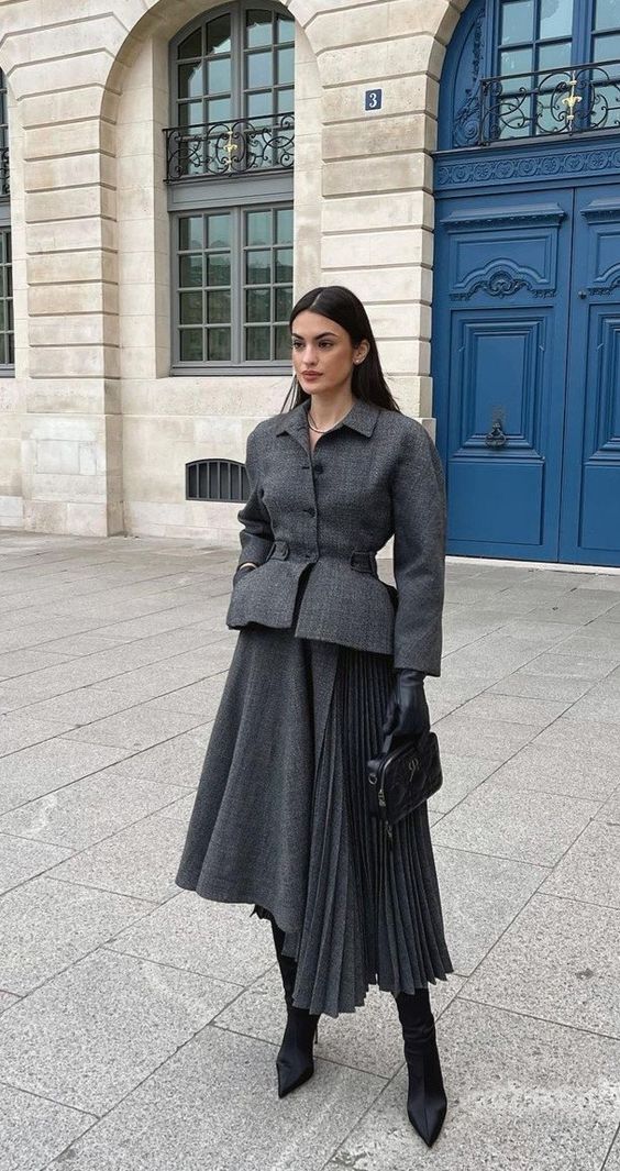 Woman in a grey wool coat, pleated midi skirt and knee-high boots winter outfit