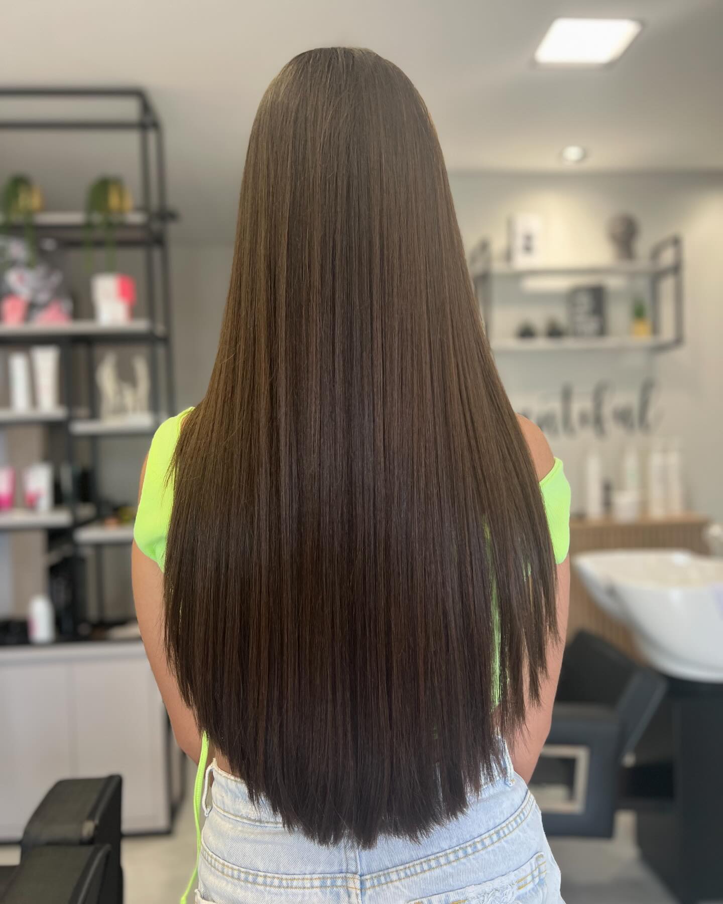 Back view of very long straight espresso hair with a V-cut layered finish