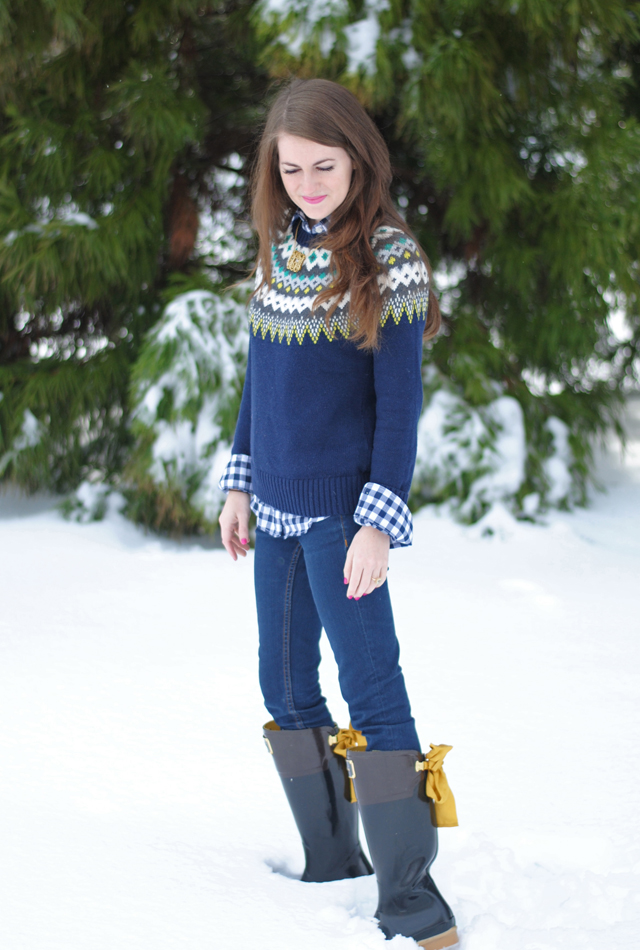 Mature woman in a gray Fair Isle yoke sweater with dark jeans and snow boots