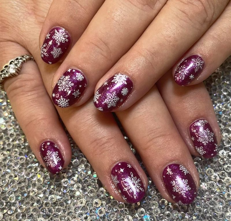 Short berry plum Christmas nails with white snowflake art