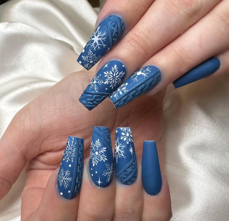 Long dusty blue matte nails with white snowflakes and cable-knit texture