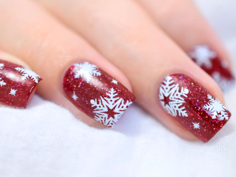 Short square nails in garnet red with white snowflake stamping