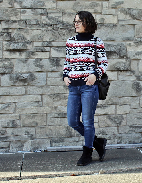 Red and navy fair-isle snowflake sweater with blue skinny jeans and black boots