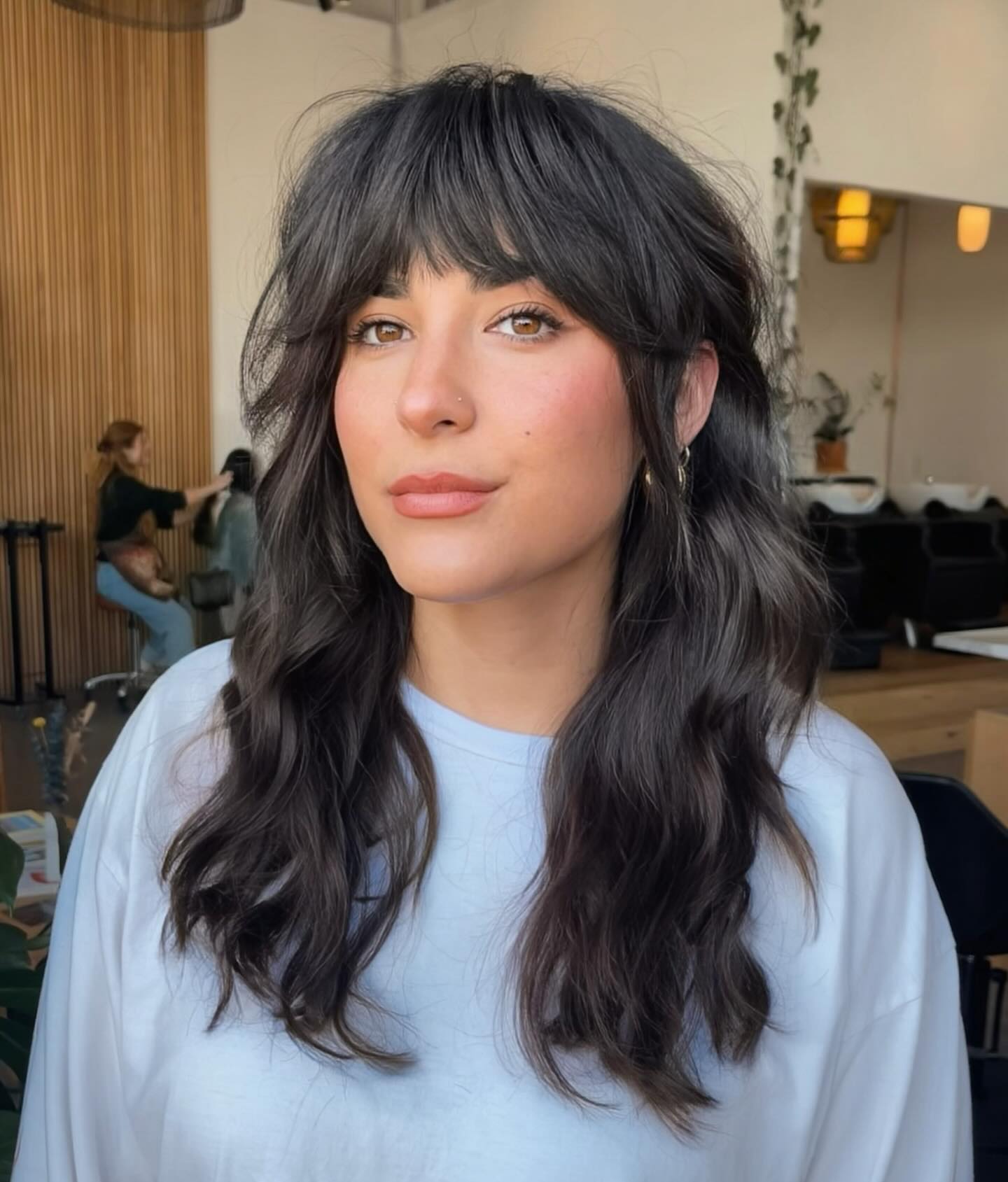 Long dark wavy hair with full wispy fringe