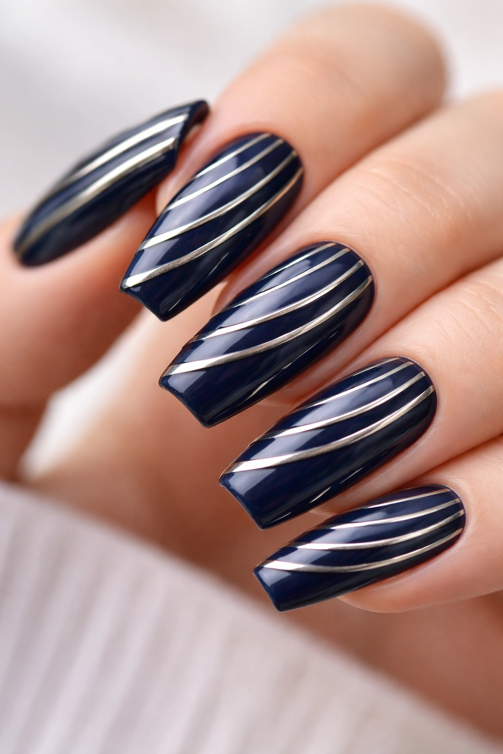 Navy nails with silver diagonal metallic stripes