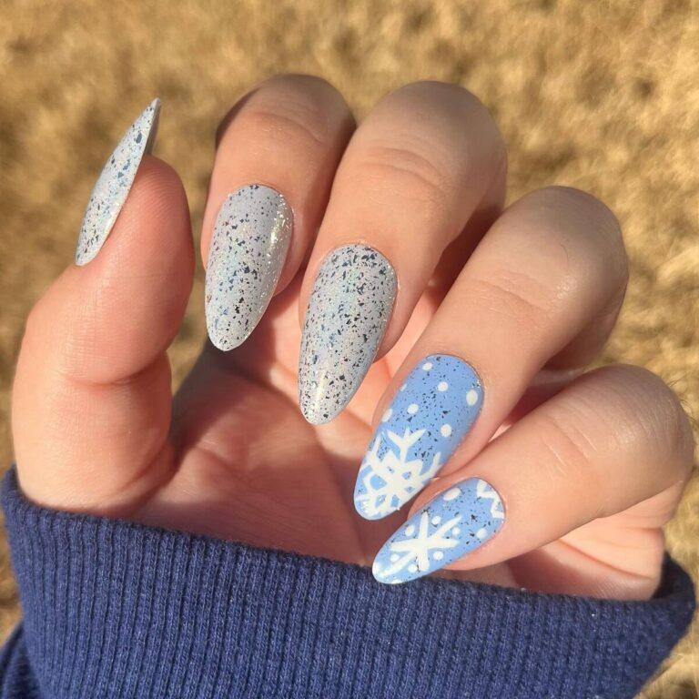 Almond icy blue nails with dark speckles and white snowflake art