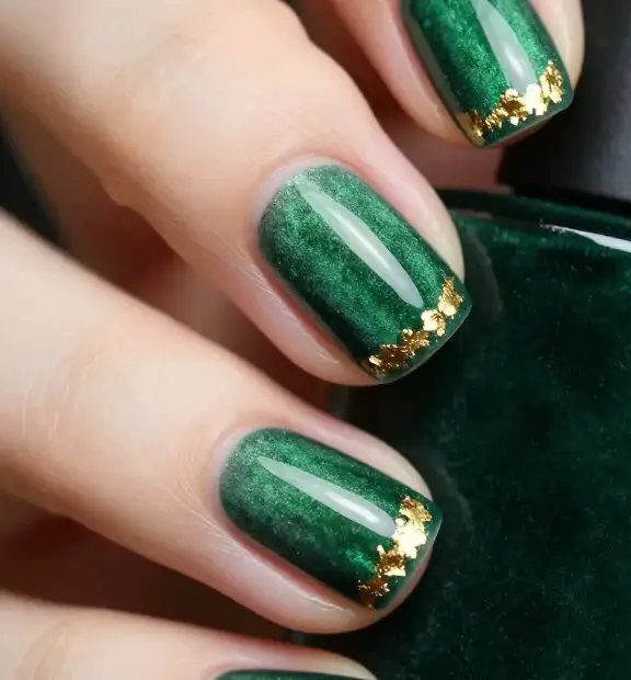 Short nails with deep forest green polish and a gold glitter accent nail