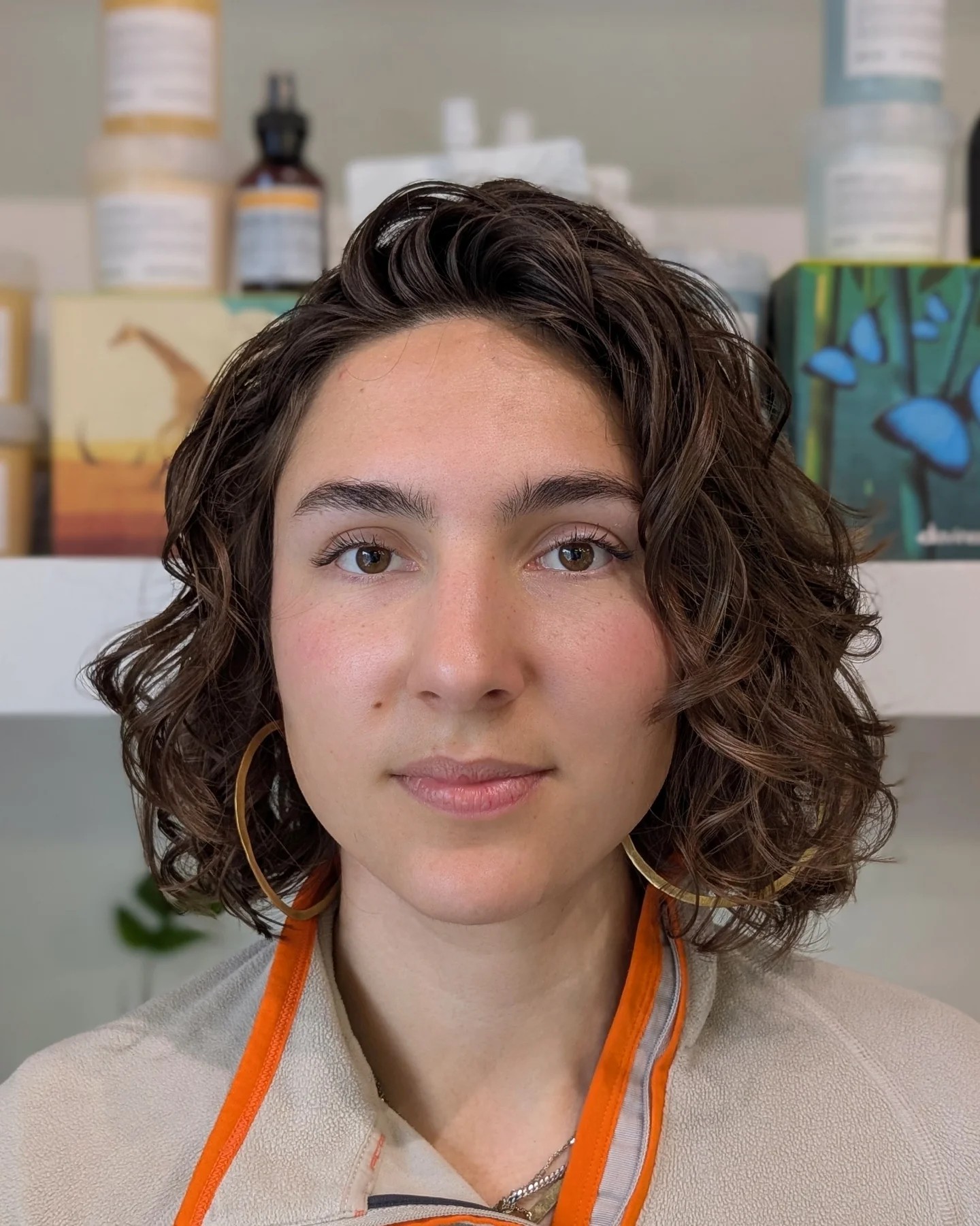 Textured chin-length curly Italian bob with crown lift and defined curls