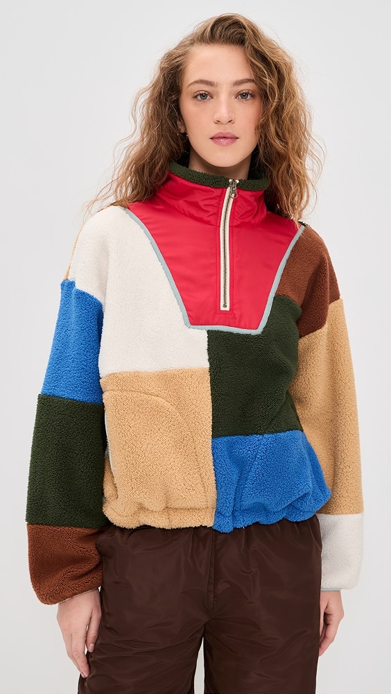 Woman in a multicolor patchwork fleece pullover with brown trousers