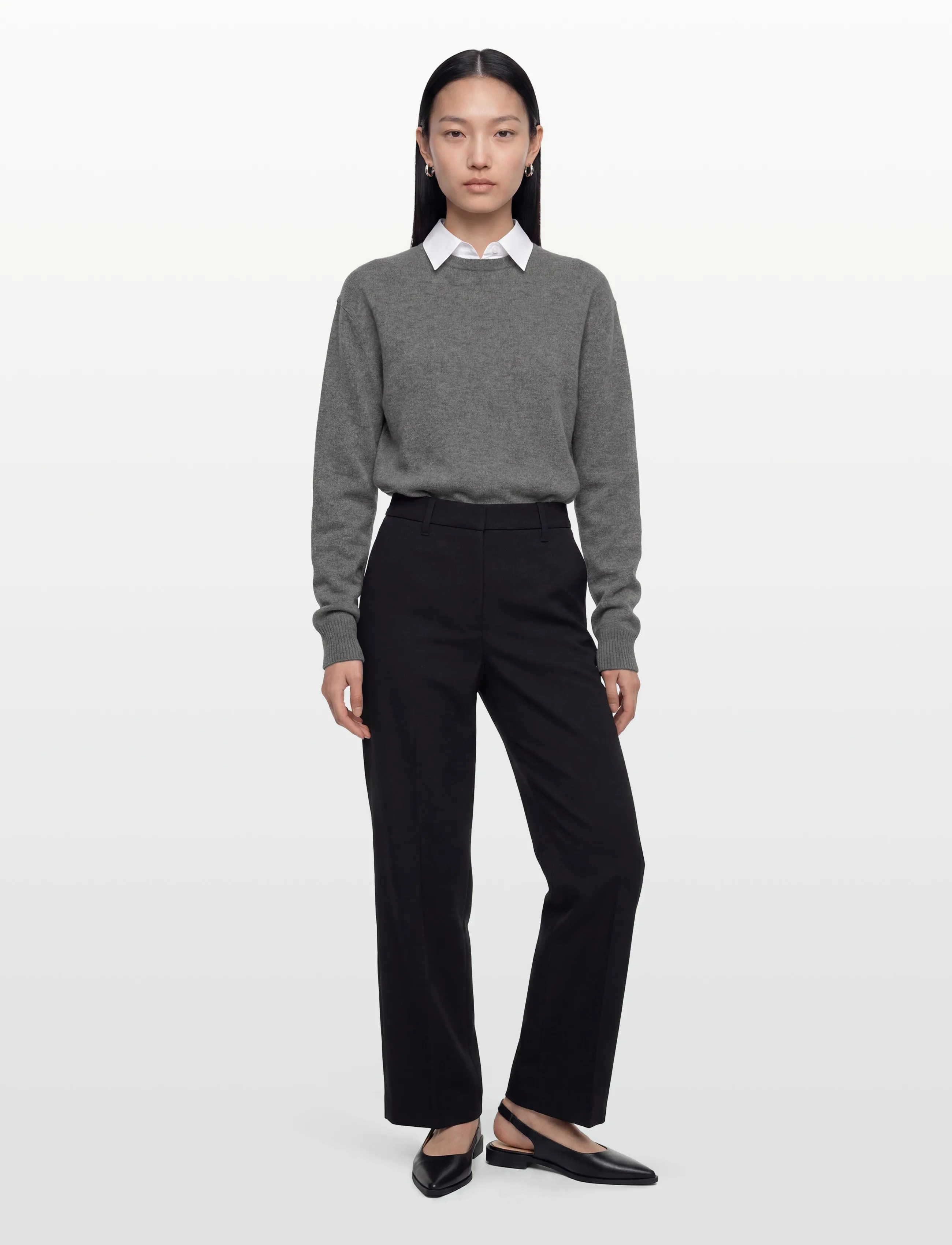 Woman in a gray cashmere sweater with black tailored trousers
