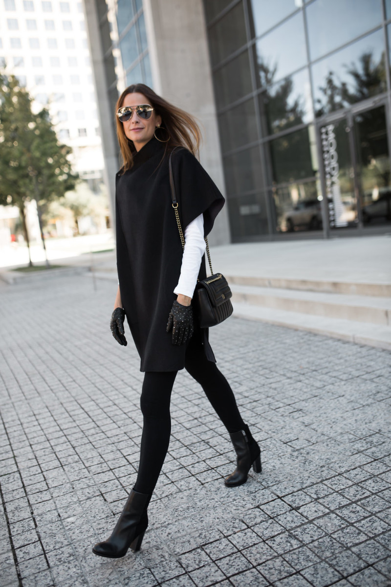 Woman wearing a wool cape with black leggings and boots