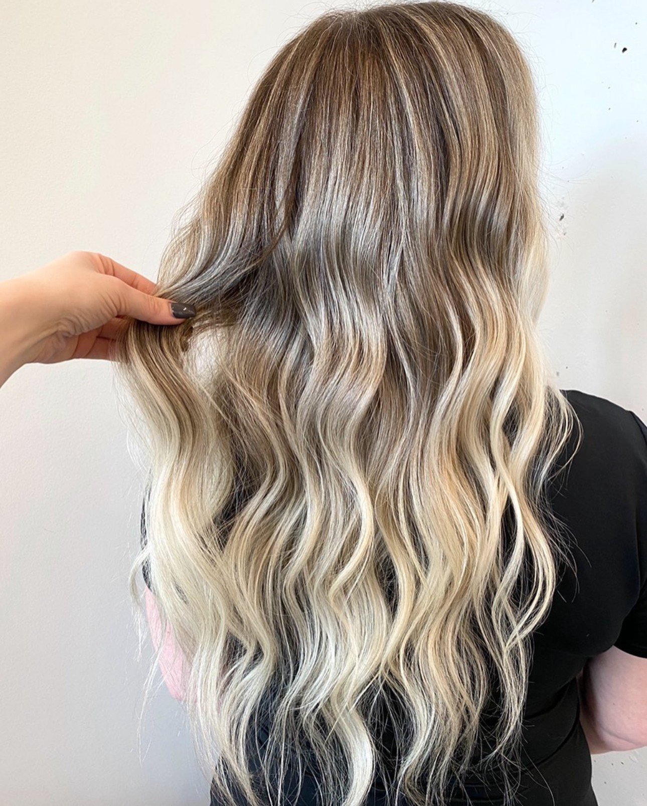 Lived-in blonde balayage with dark roots on long hair
