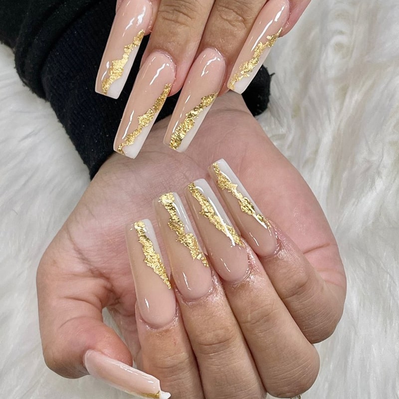 Long coffin nails with gold foil streaks on a nude base