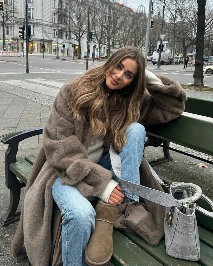 Woman wearing Ugg Coquette slippers with a satin midi skirt and oversized blazer