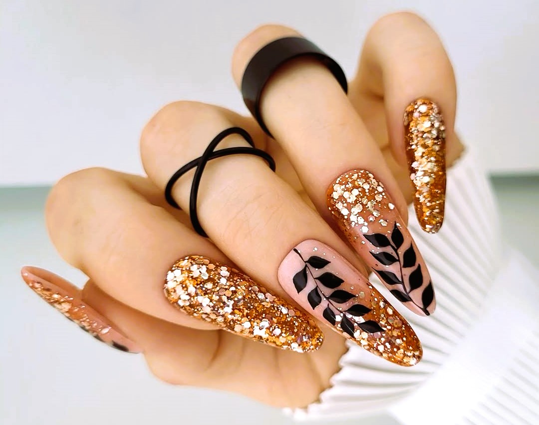 Long coffin nails with copper glitter and black leaf nail art