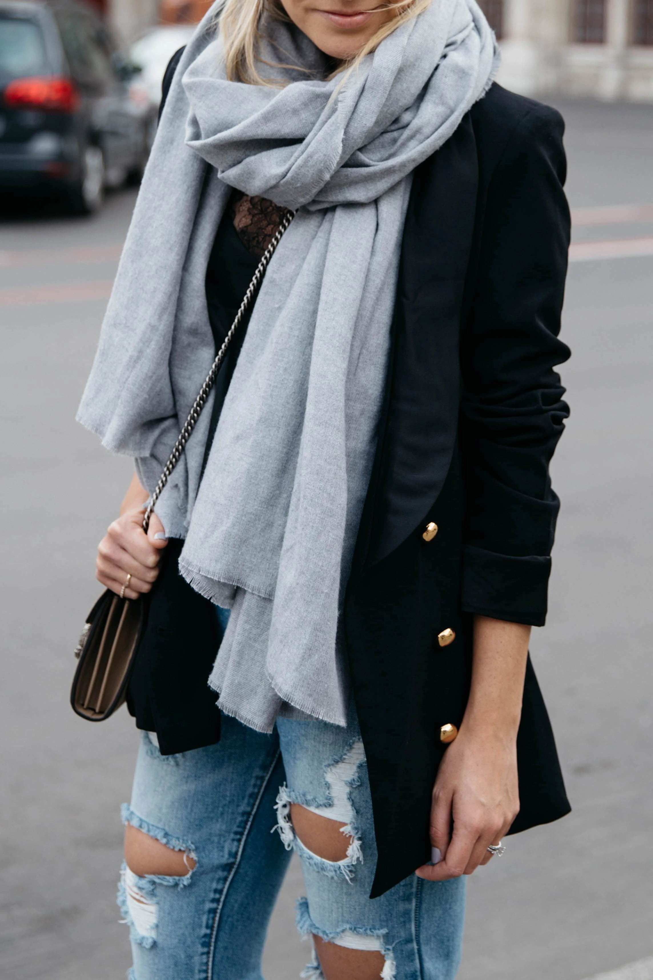 Woman in a black blazer with a scarf and jeans