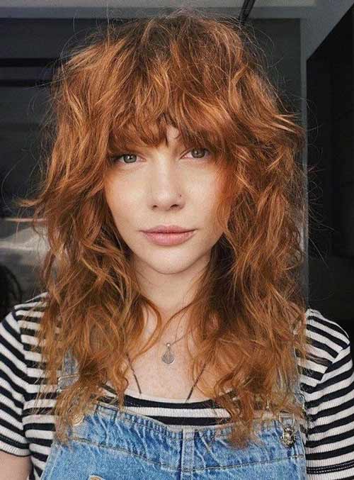 Curly copper red shag haircut with bangs