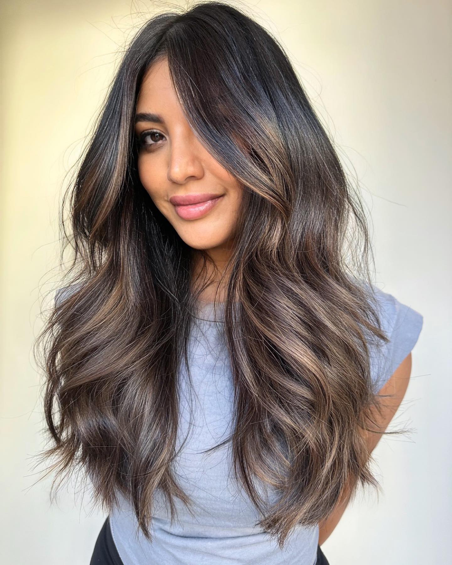 Long wavy hair with ash brown balayage and dark roots