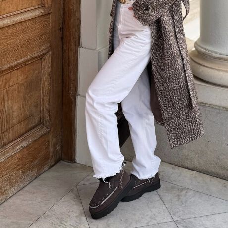 Brown tweed coat with white jeans and dark brown whipstitched ugg moccasin boots