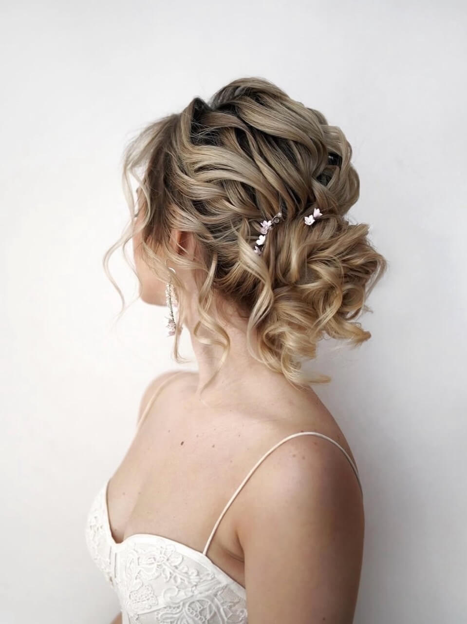 Blonde curly bridal updo with small decorative pins
