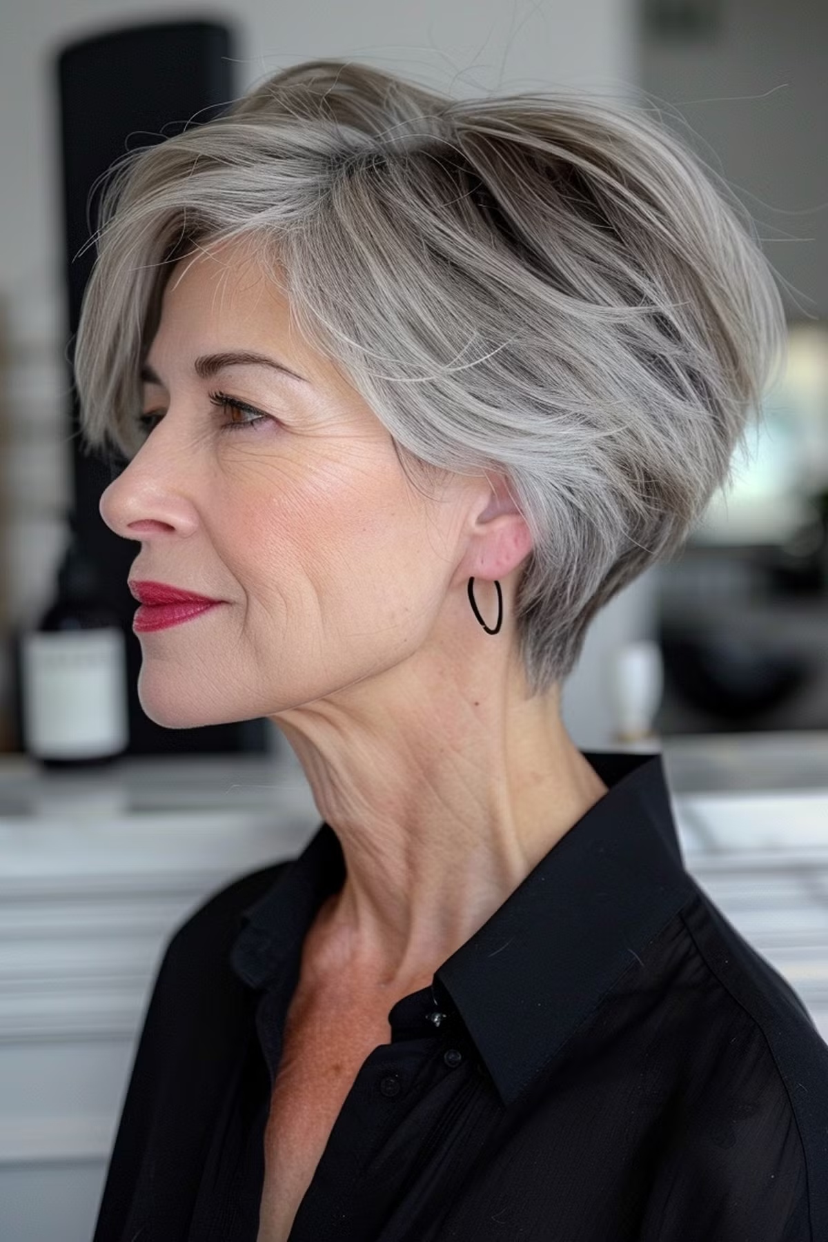 Older woman in profile with a voluminous silver wedge haircut