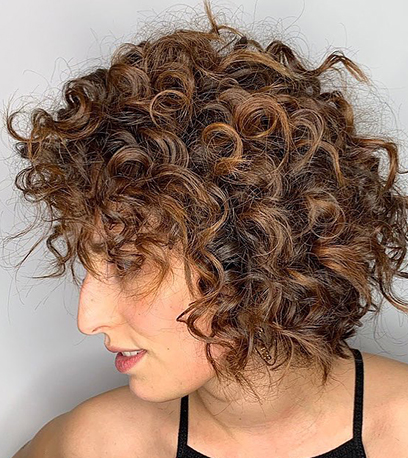 Chocolate brown curly lob haircut with a soft curly fringe