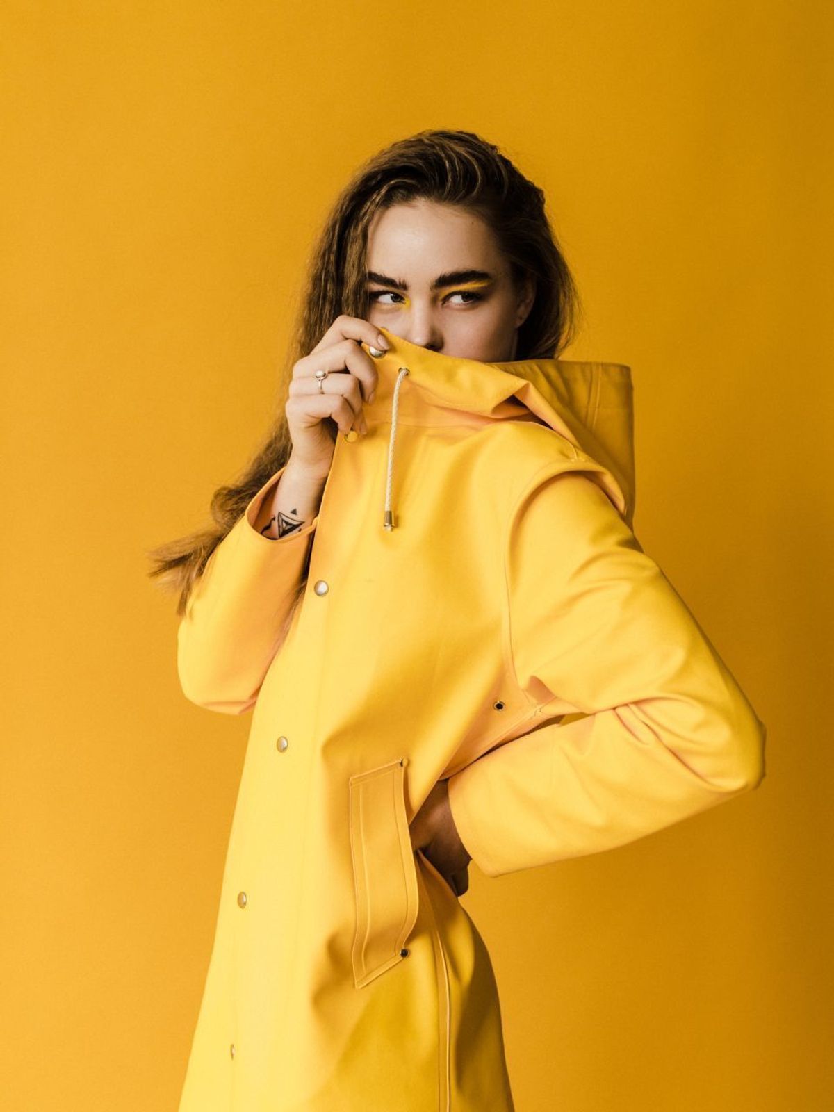 Woman wearing a yellow raincoat over city winter layers