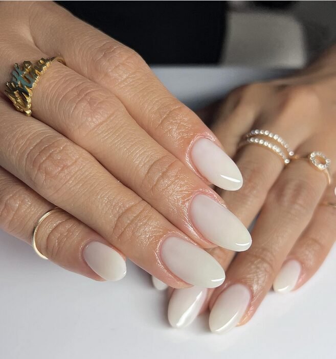 Milky white polish on almond-shaped nails